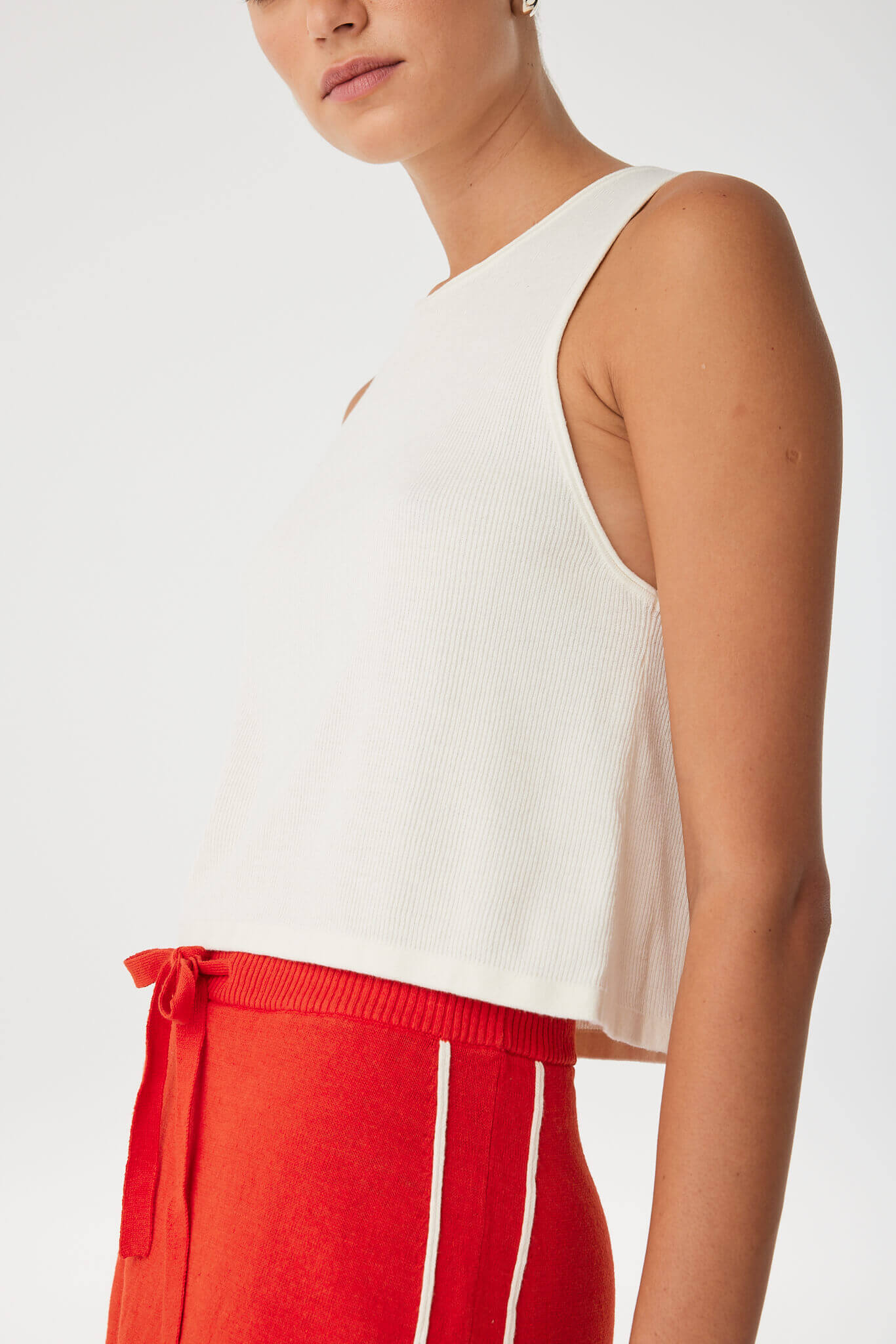 Close-up of flared hem and subtle ribbing in cream organic cotton–hemp tank, highlighting movement and softness.