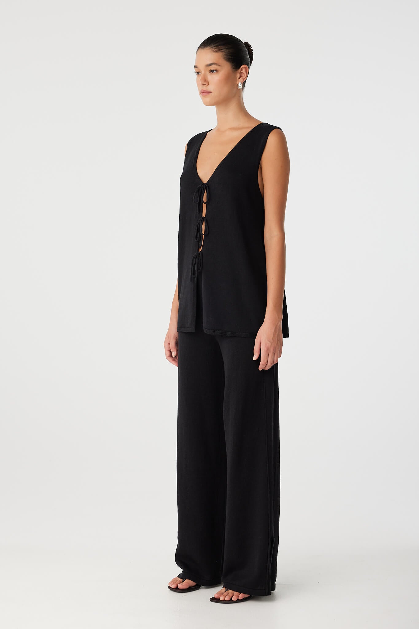 Side view of reversible top in black linen–cotton blend with soft drape and relaxed longline fit.
