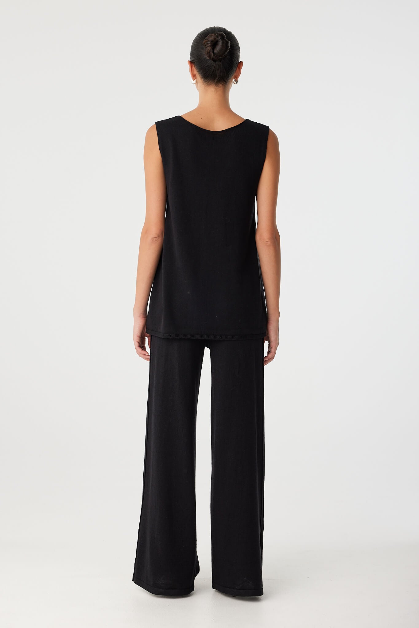 Back view of reversible top worn with V detail at front, showing full coverage and longline hem in breathable fabric.
