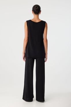 Back view of reversible top worn with V detail at front, showing full coverage and longline hem in breathable fabric.