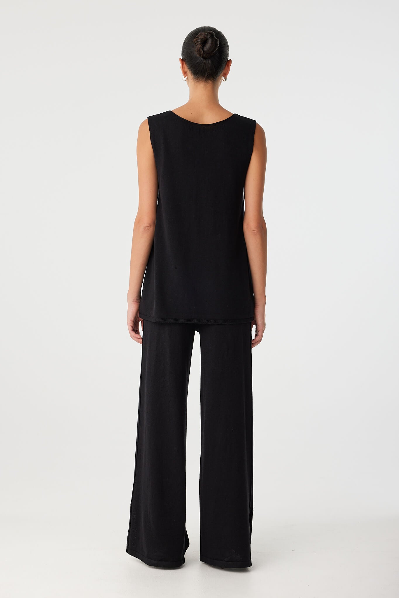 Back view of matching black linen–cotton set featuring wide-leg pants and sleeveless top, highlighting relaxed drape and breathable texture for all-day comfort.