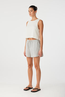 Side view of black check cotton shorts designed for airflow and casual wear, styled with flat sandals.