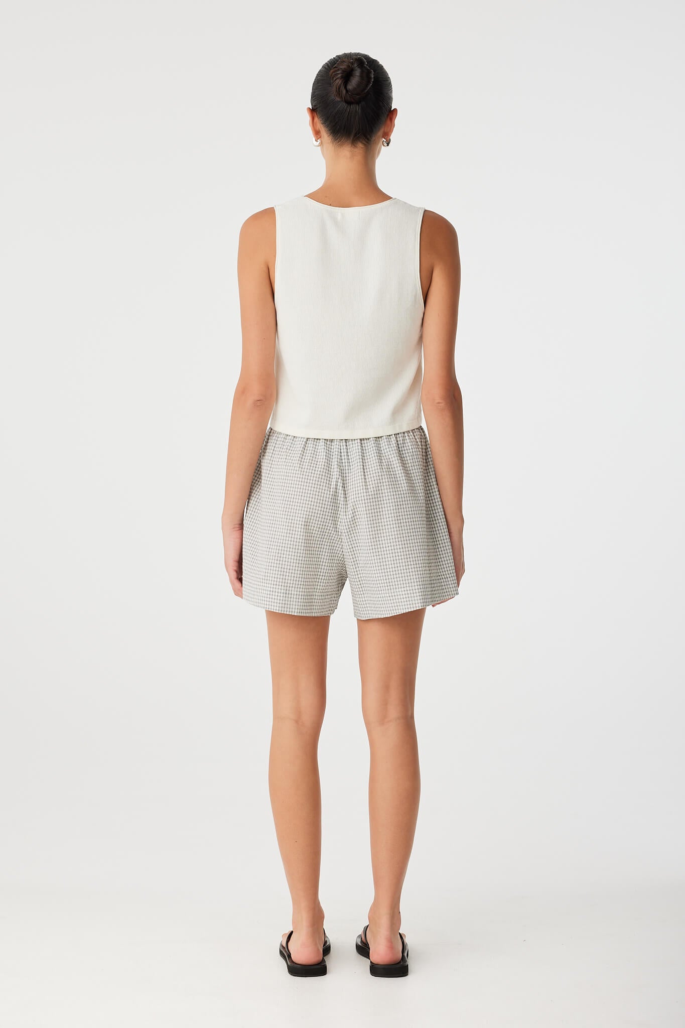 Relaxed drawstring shorts paired with tank top, ideal for warm-weather layering and effortless travel looks.