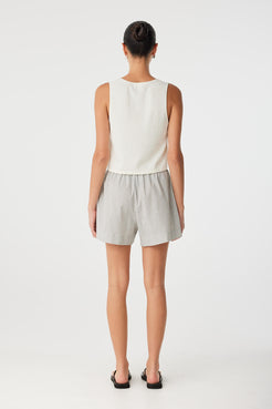 Relaxed drawstring shorts paired with tank top, ideal for warm-weather layering and effortless travel looks.