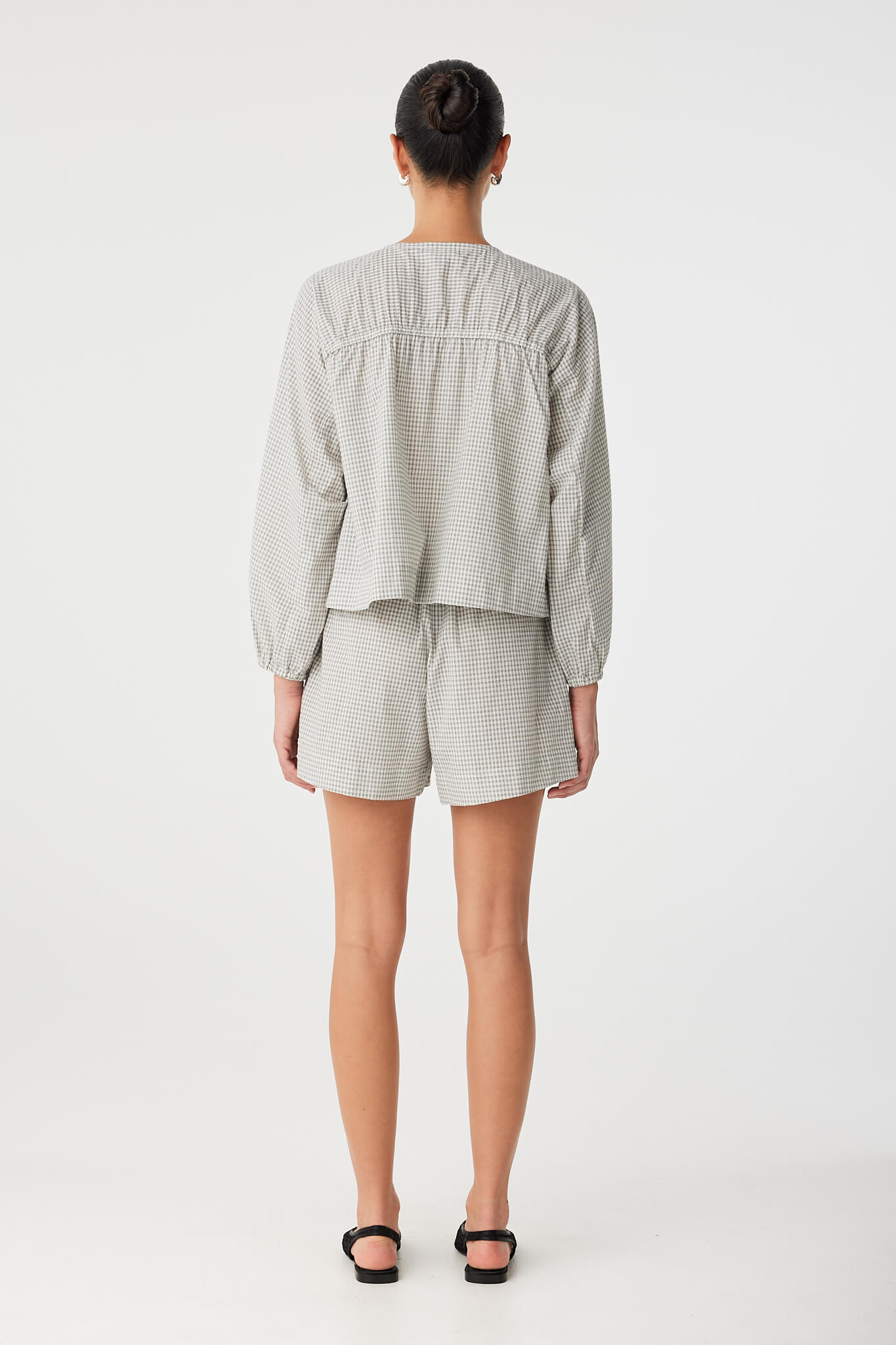 Back view of relaxed blouse in breathable cotton check showing soft drape and clean finish.