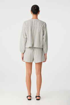 Back view of relaxed blouse in breathable cotton check showing soft drape and clean finish.