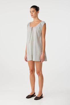 Cotton check dress in motion, showing drape and ease through the hem—perfect for layering or transitional climates.