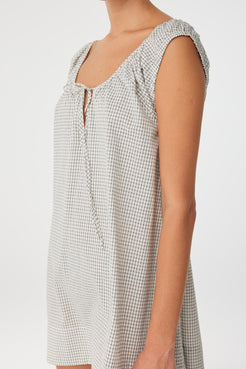 Close side profile of black check dress showing texture and flow, crafted in lightweight cotton for seasonal versatility.