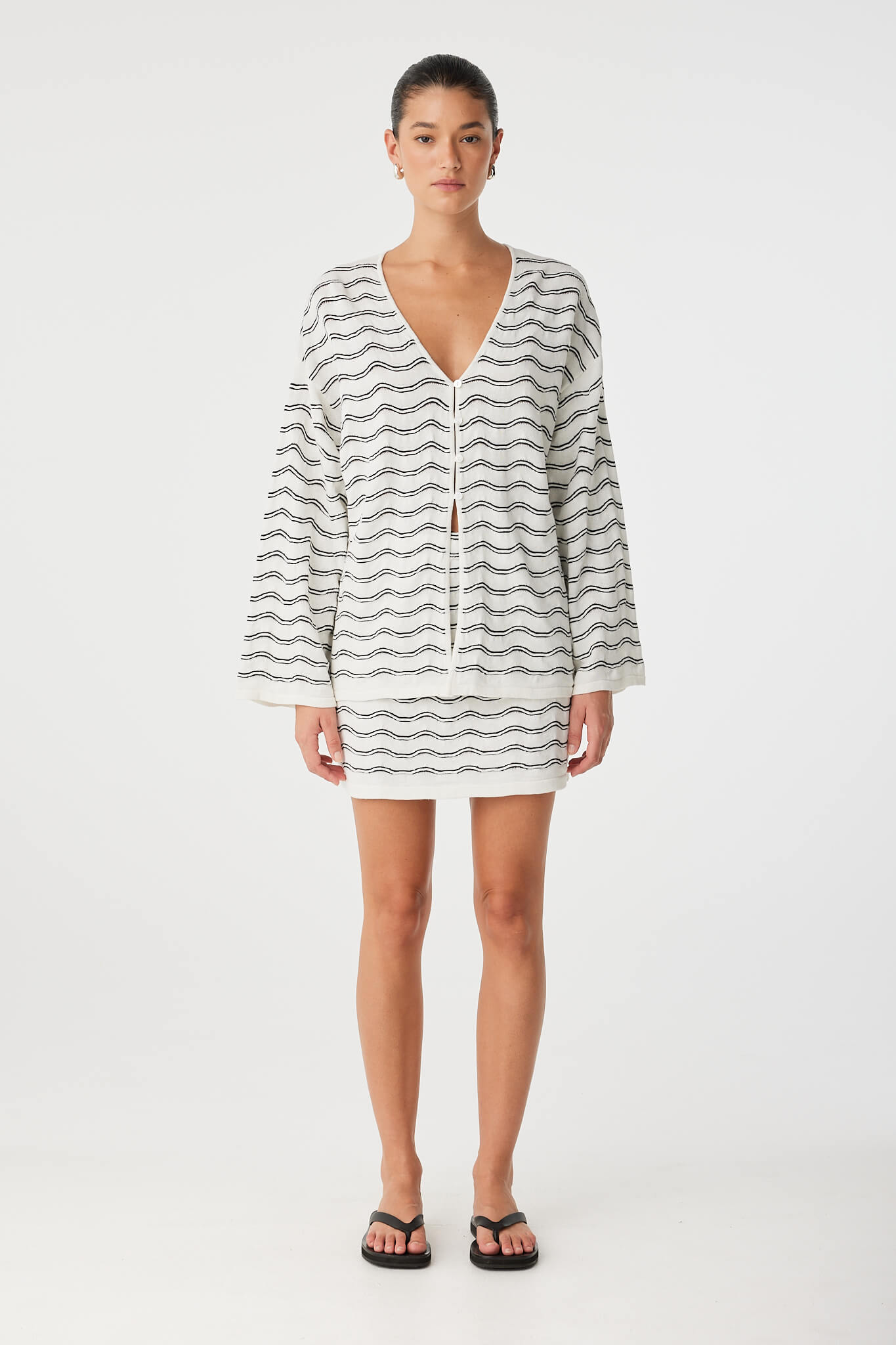 V-neck long sleeve top in wave knit, styled for warm-weather layering.