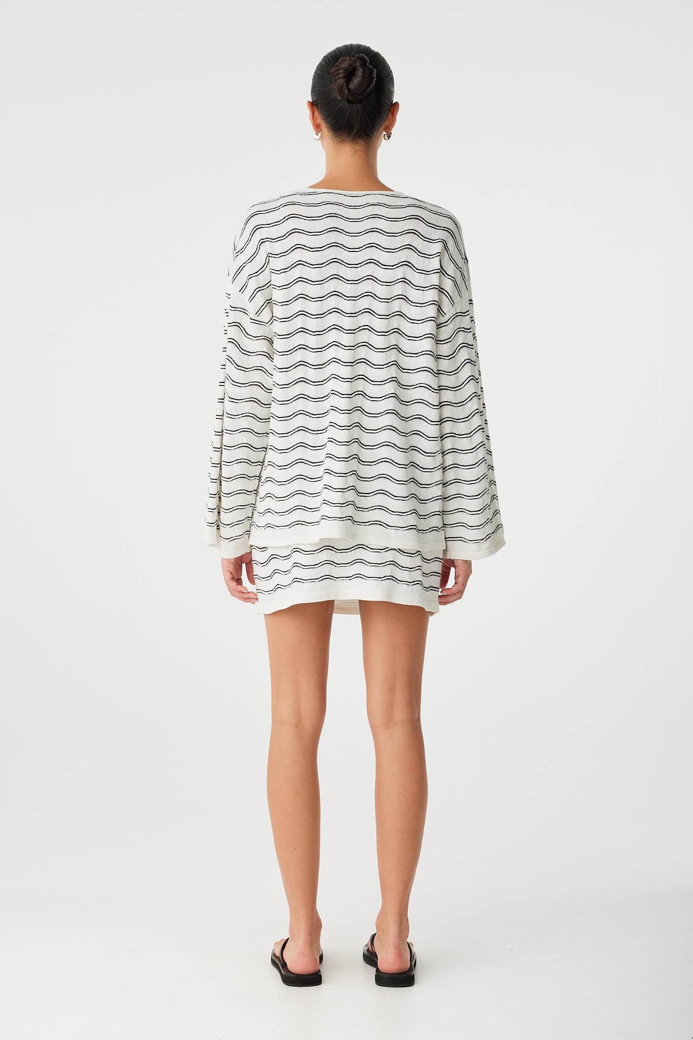 Back view of long sleeve top in cream and black wave knit, showing relaxed silhouette.