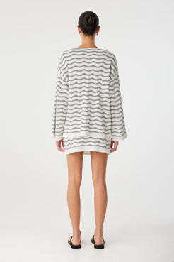 Back view of long sleeve top in cream and black wave knit, showing relaxed silhouette.