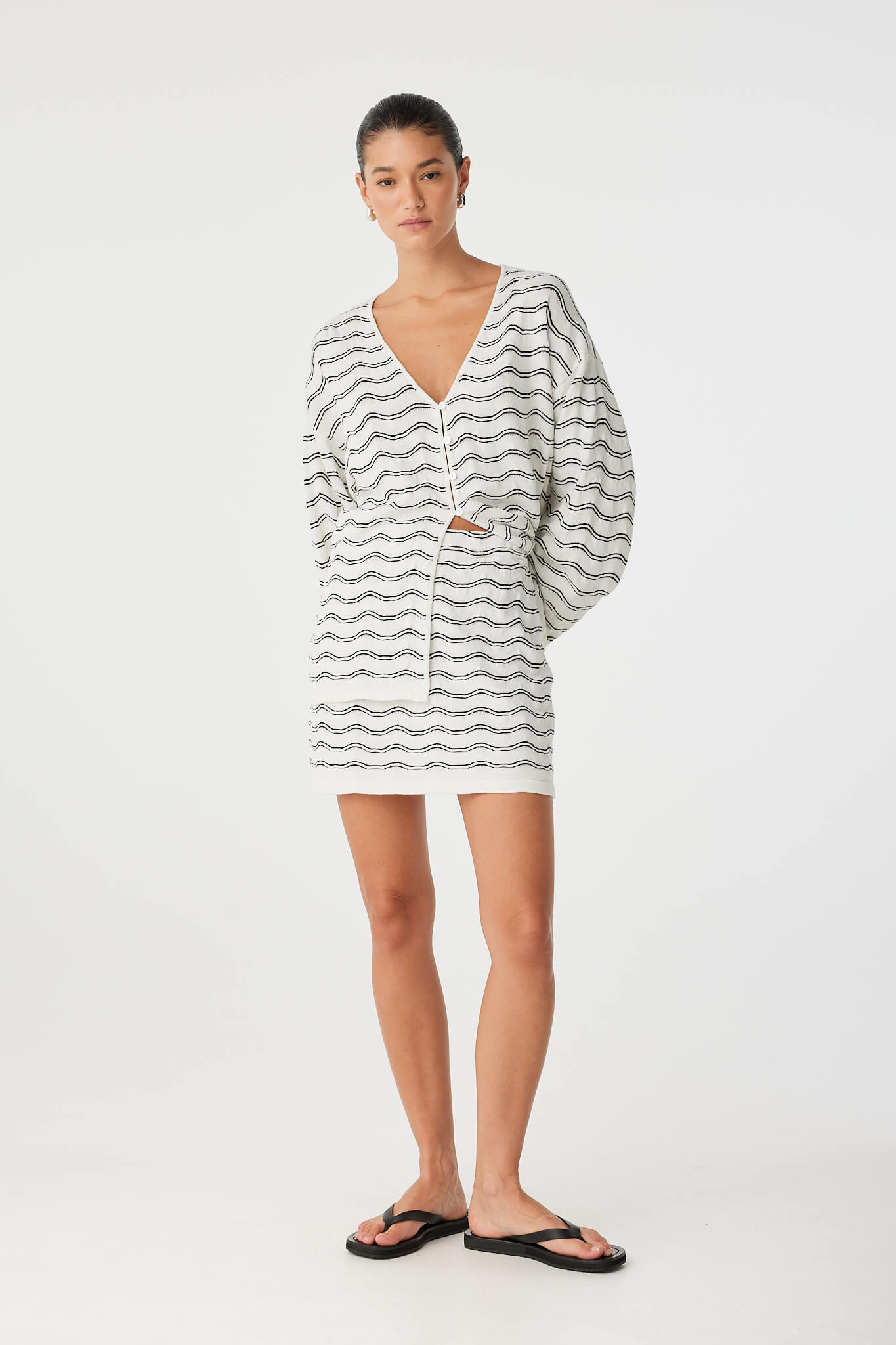 Relaxed styling of mini skirt and knit top, soft textures and tonal cream palette.