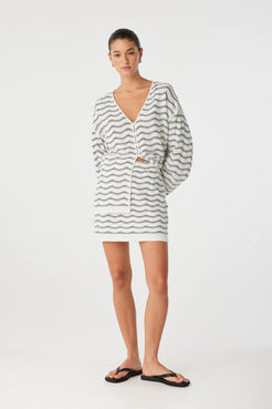 Relaxed styling of mini skirt and knit top, soft textures and tonal cream palette.