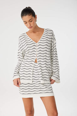 Soft moment in relaxed wave knit top, highlighting natural fall of sleeves and open front.