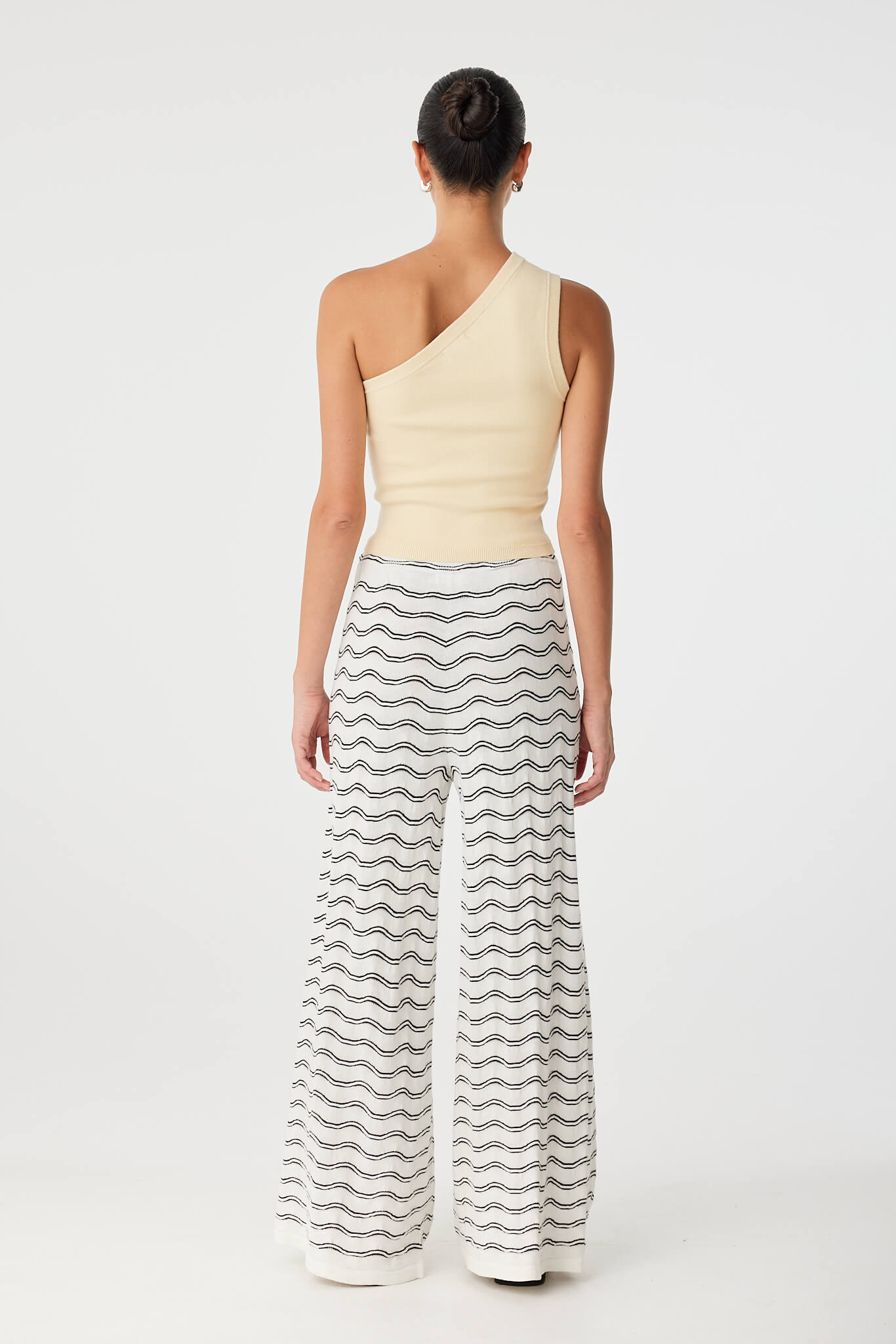 Back view of Onda Pant styled with fitted tank, revealing relaxed drape and clean knit texture.