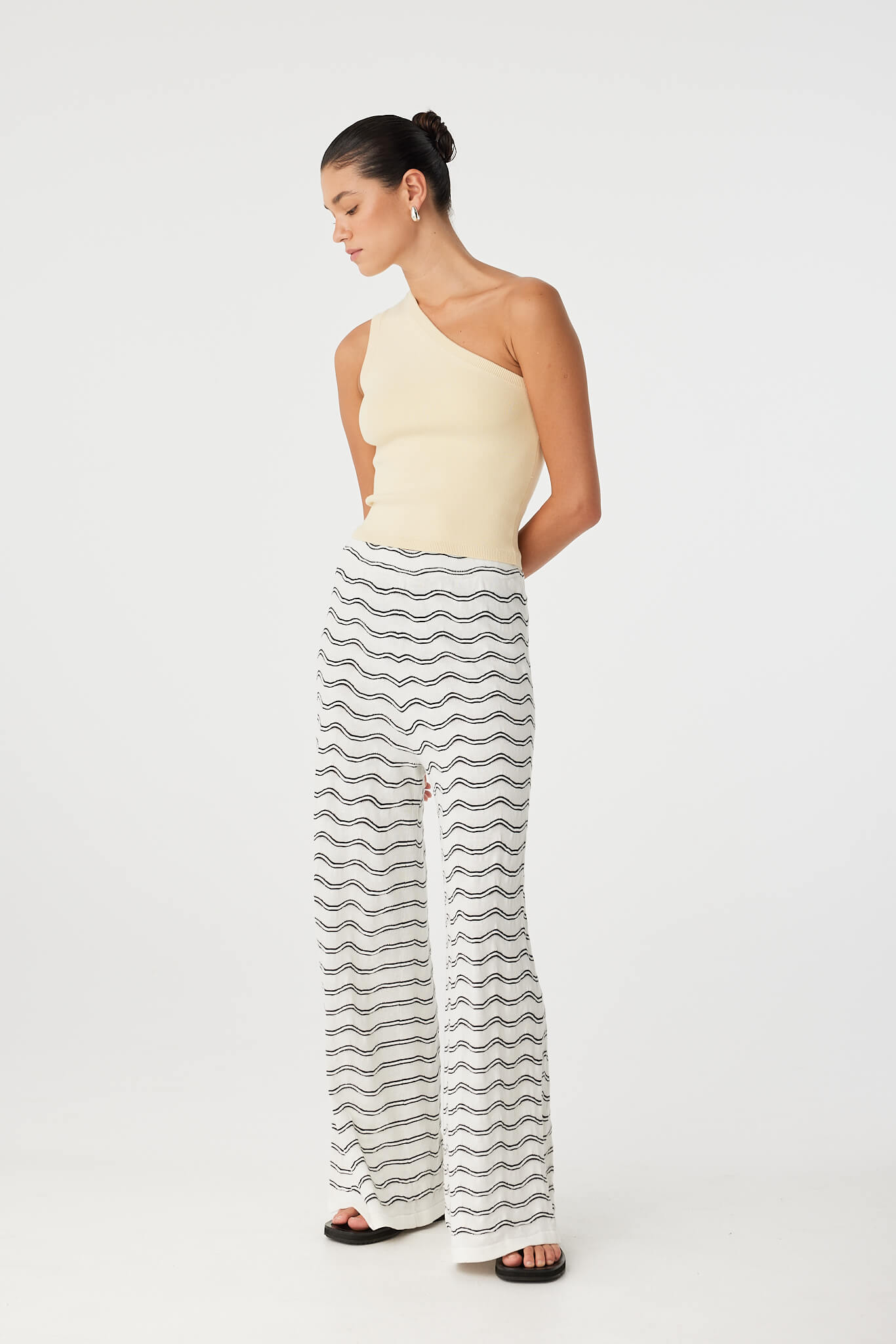 Relaxed moment in fitted tank and printed pants, highlighting movement and shape.