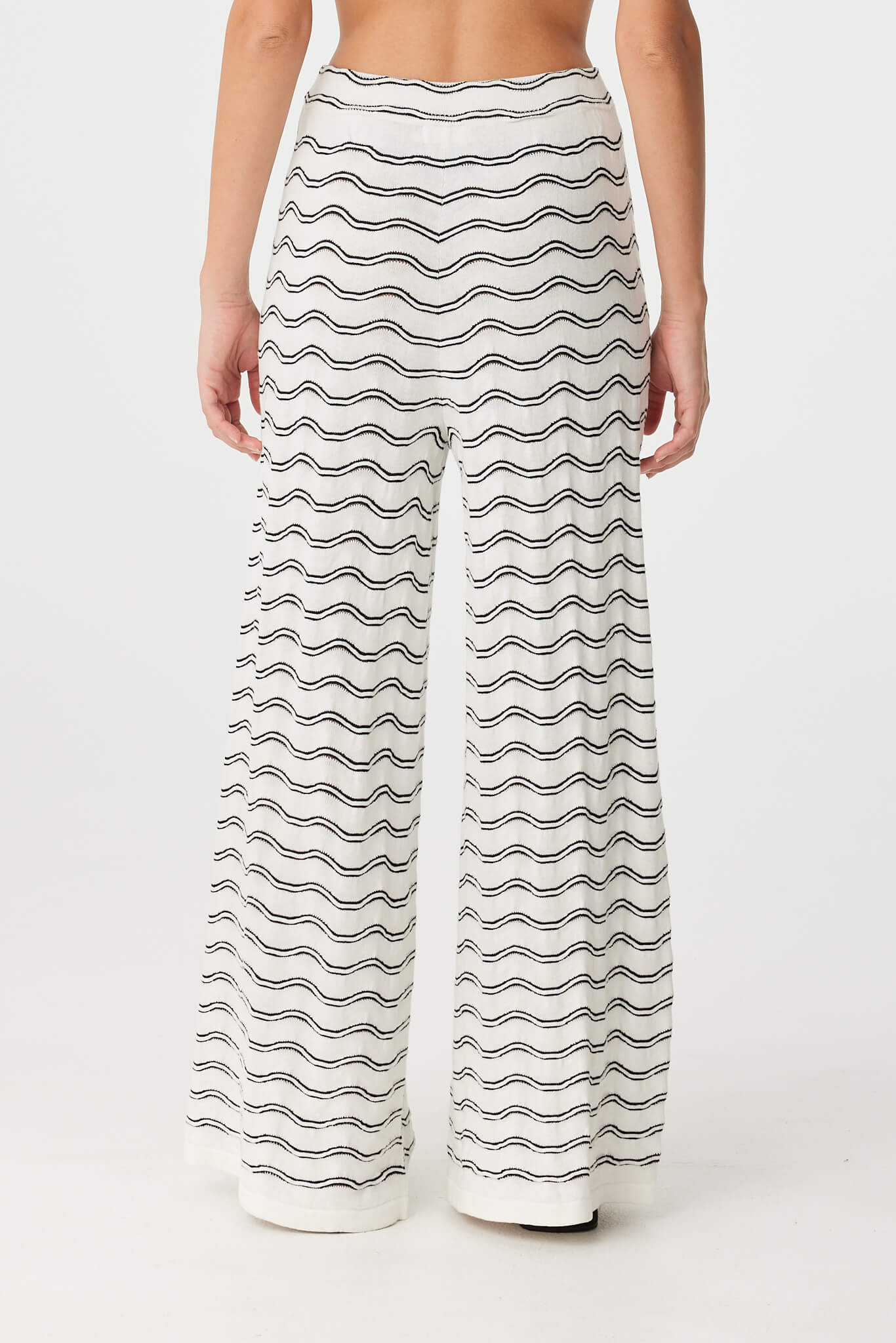 Back view of cream and black wave knit pants with elastic waistband and soft wide-leg cut.