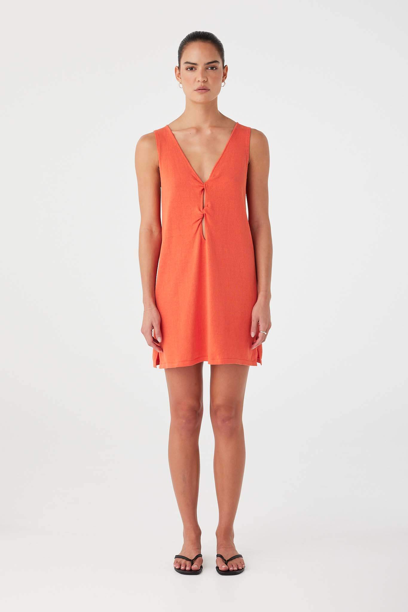 Model wearing mandarin linen–cotton mini dress with twist-front cutout detailing.