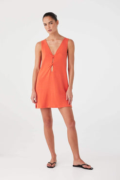 Model in orange (mandarin) linen–cotton mini dress with twist-front cutout, designed for versatile summer wear.