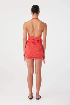 Halter-style coral knit top with open back and adjustable ties, cut in recycled rayon viscose.