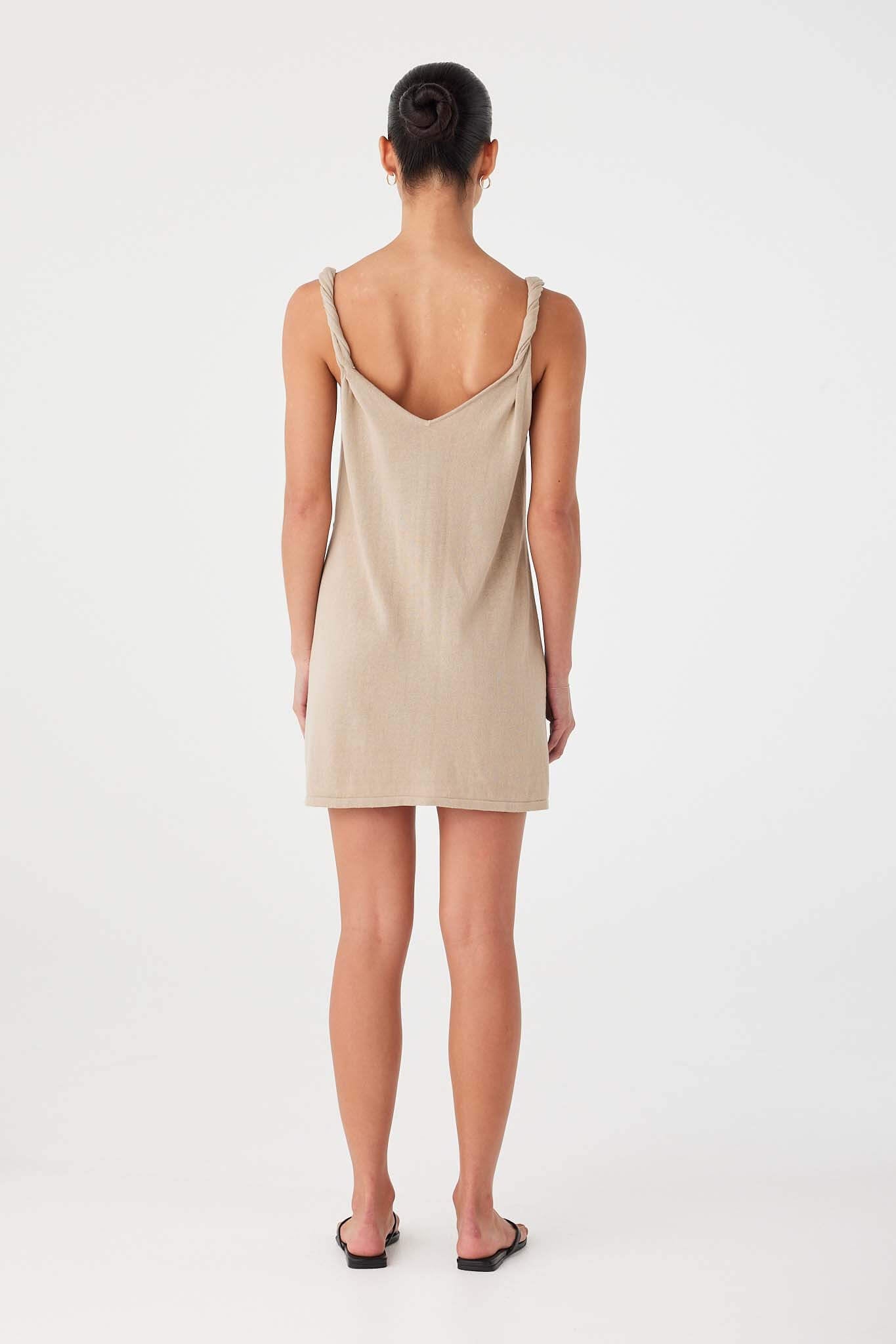 Back view of taupe linen–cotton dress with twisted straps and clean straight cut.