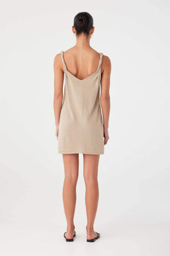 Back view of taupe linen–cotton dress with twisted straps and clean straight cut.