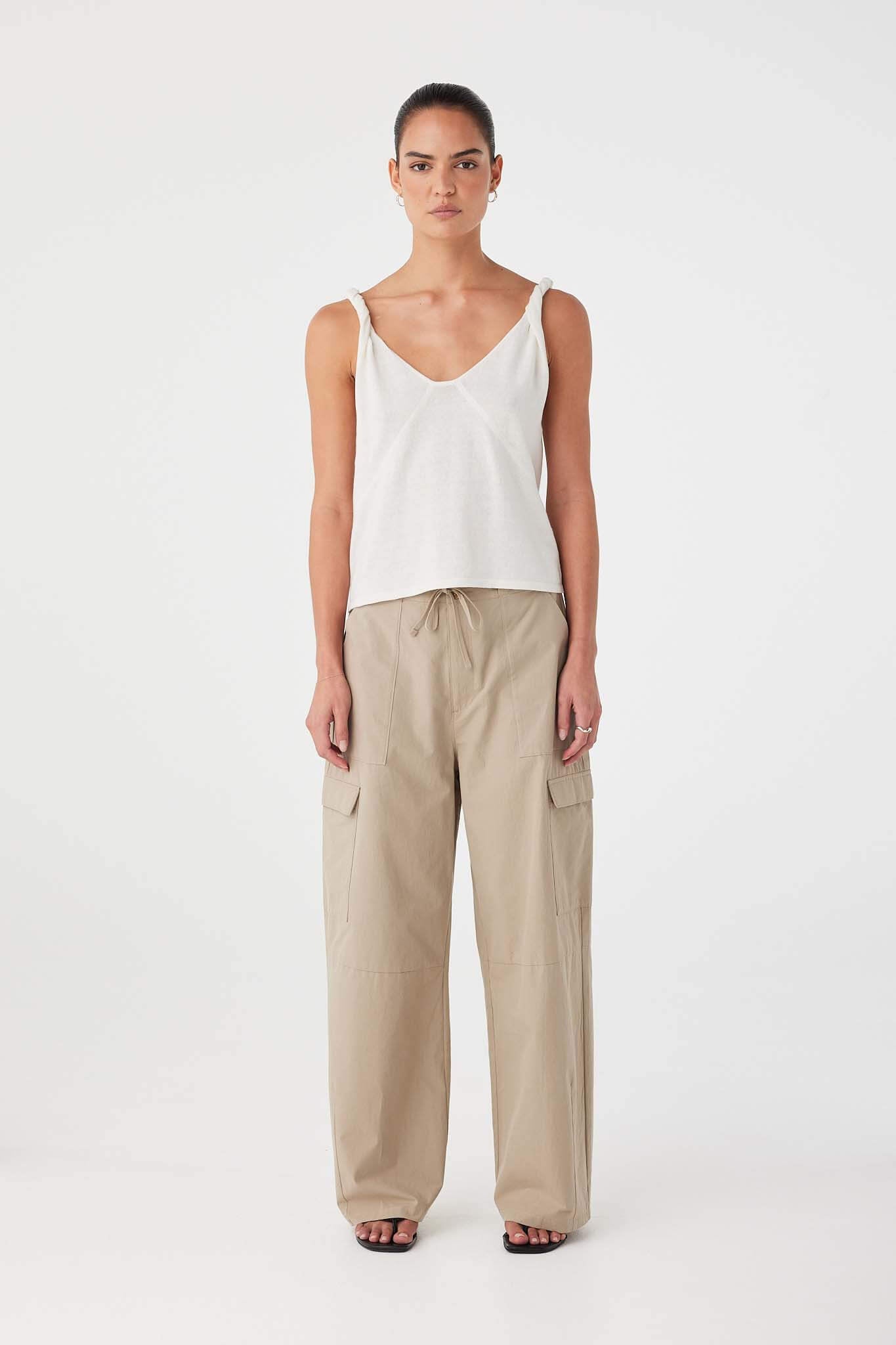 Full-length look of cream linen cotton tank with shaping seams and relaxed fit, paired with wide-leg pants for summer layering.