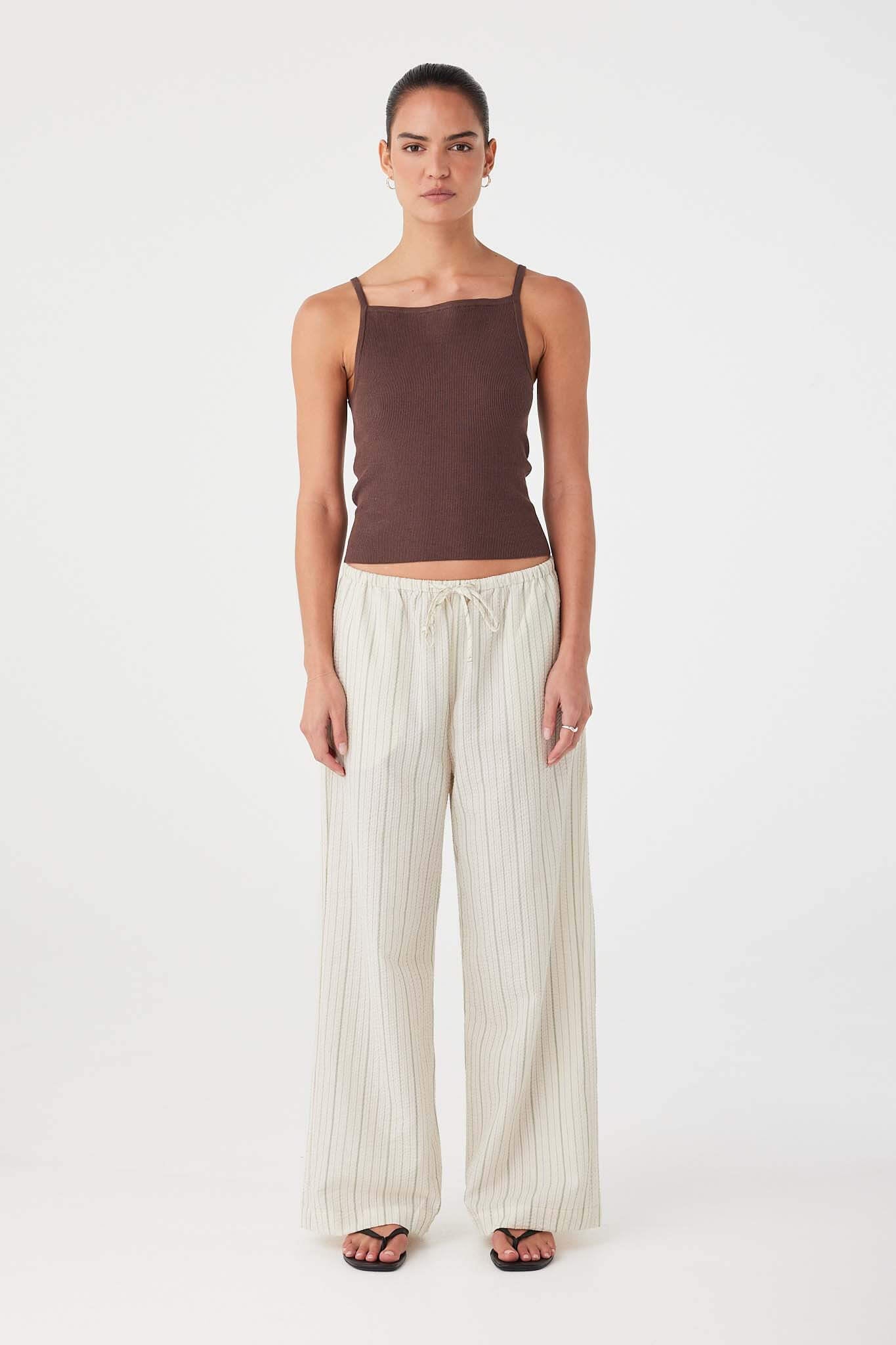 Model wearing olive stripe wide-leg cotton pants with drawstring waist and relaxed fit.