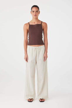 Model wearing olive stripe wide-leg cotton pants with drawstring waist and relaxed fit.