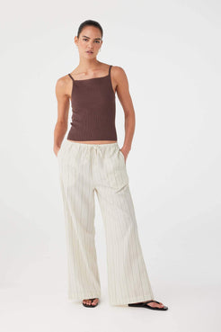 Model in olive stripe cotton drawstring pants styled with brown tank top for warm-weather ease.