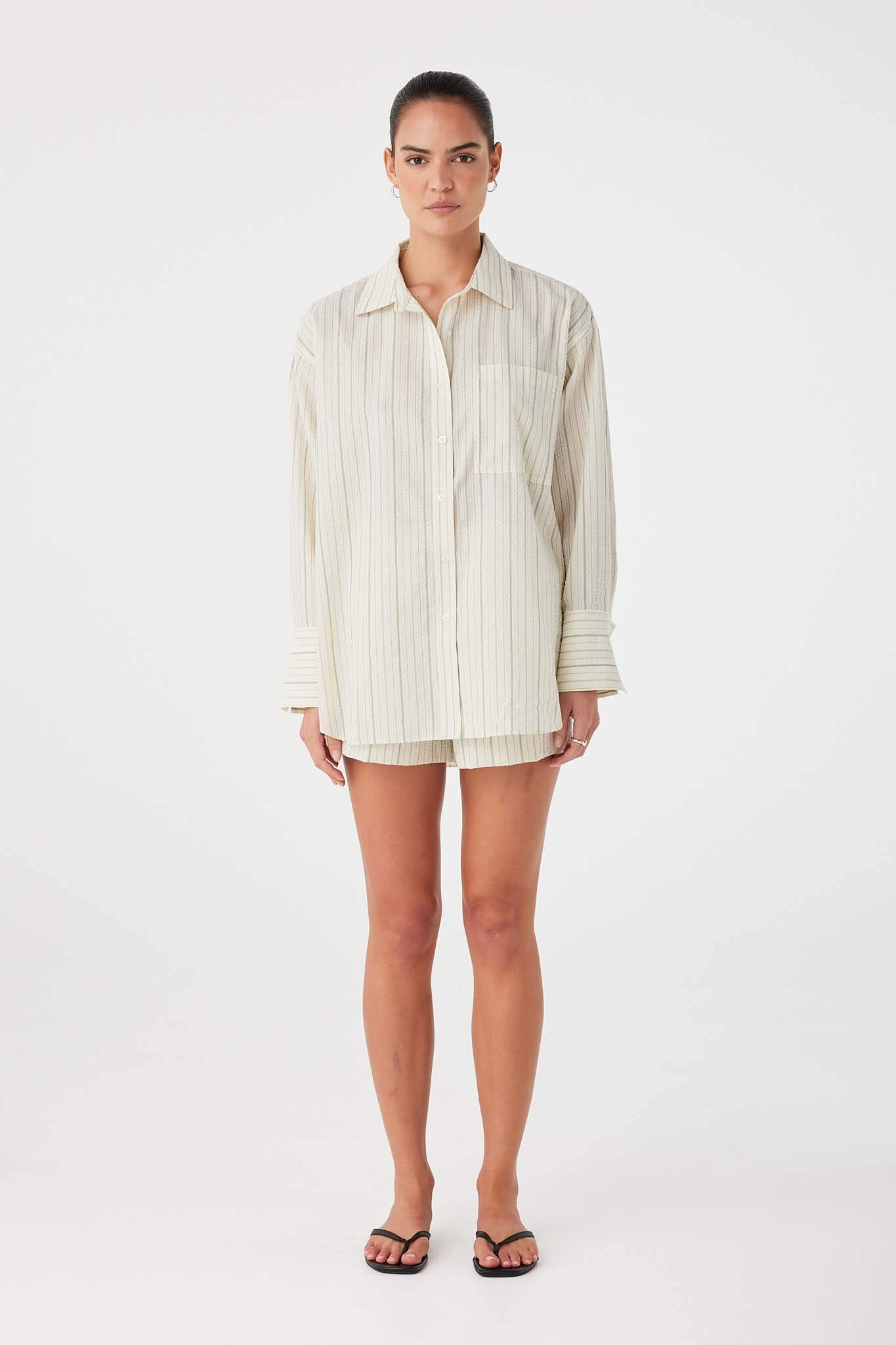 Model in olive stripe cotton boxer shorts with elastic waistband and button fly detail.
