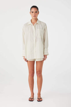 Model wearing oversized olive stripe cotton shirt with button-down front and classic collar.