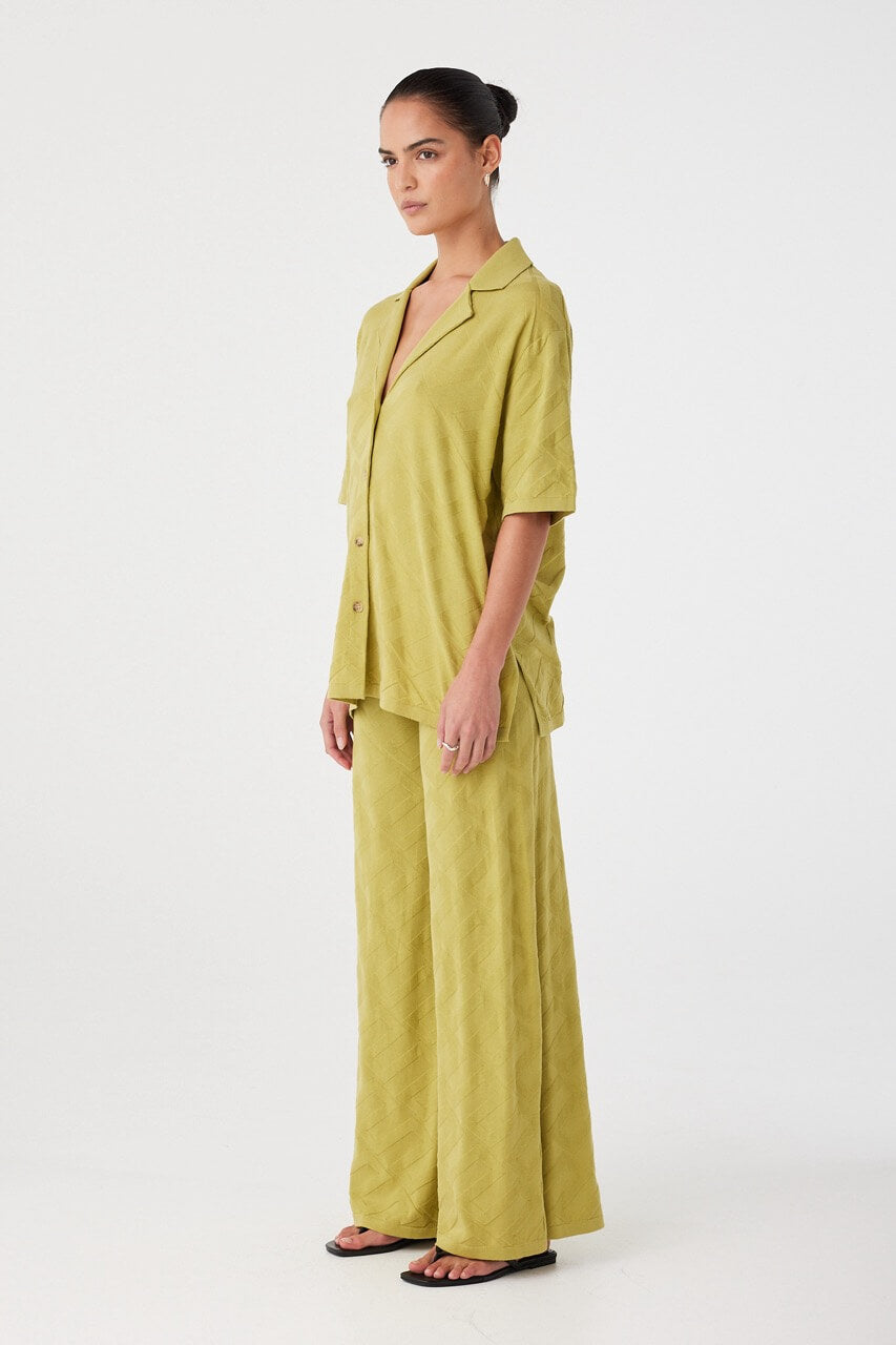 Side profile of oversized shirt in patterned organic cotton knit. Designed for breathability and ease of movement.