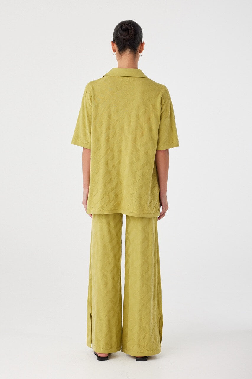 Back view of relaxed-fit matcha shirt with straight hem and soft drape. Crafted in breathable textured knit for seasonal layering.