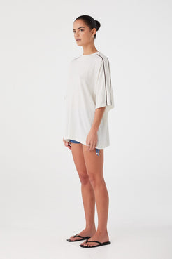 Side profile of oversized tee showing curved drape and lightweight knit texture. Designed for comfort and breathability.