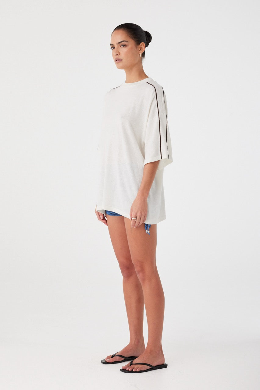 Side profile of oversized tee showing curved drape and lightweight knit texture. Designed for comfort and breathability.