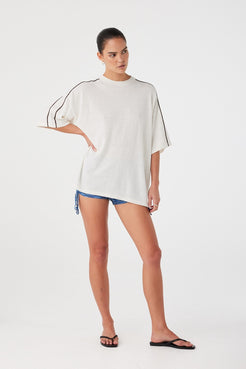Model styled in contrast stripe oversized tee with loose fit and dropped sleeves. Breathable knit ideal for warm-weather dressing.