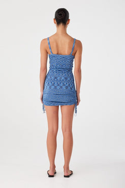 Back view of blue crochet mini dress with low-cut back and clean edge finish. Close fit designed for warm climates.
