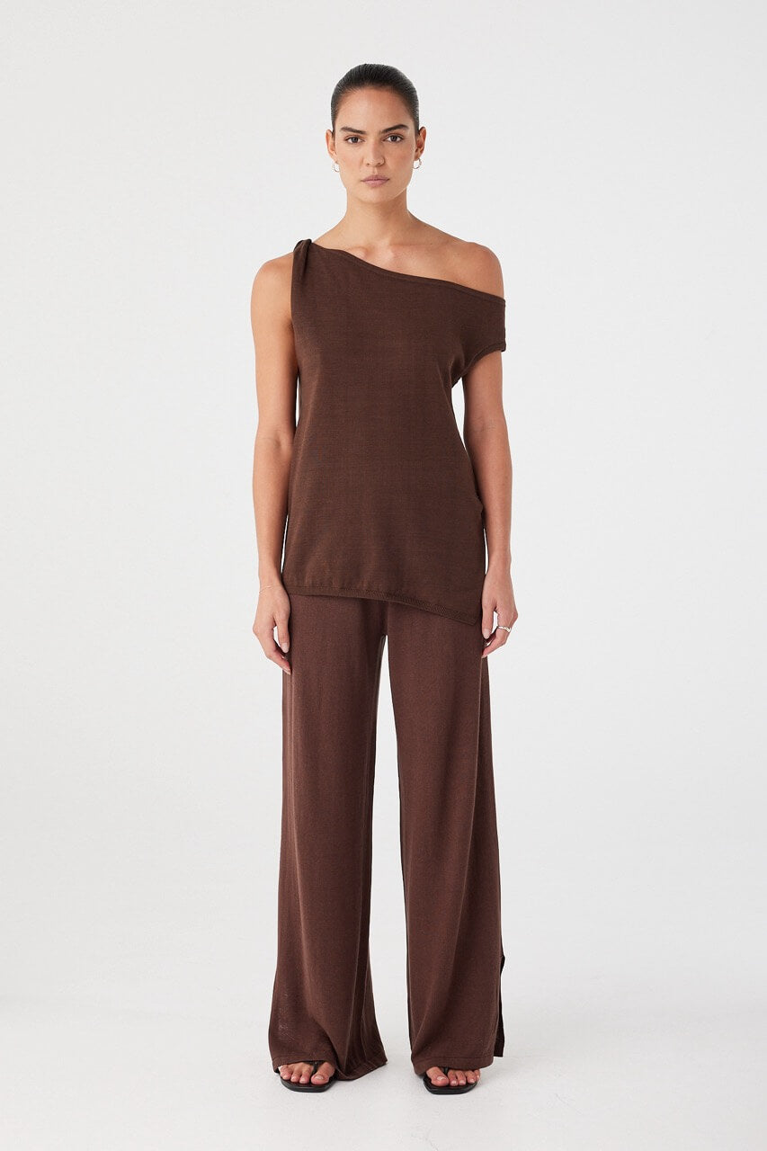 Model in brown cotton knit co-ord set featuring Olympia Asymmetric Top and matching pants, made from 100% breathable cotton.