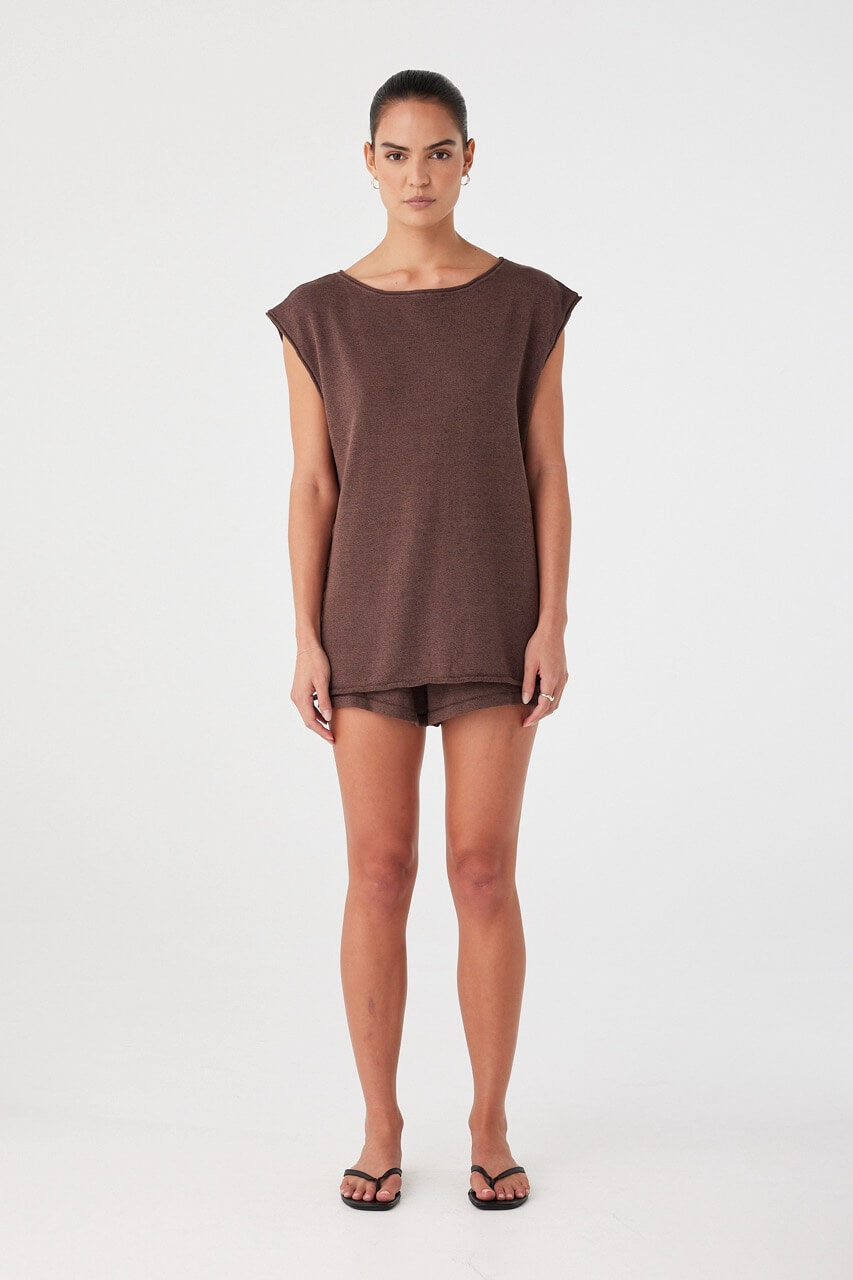 Model wears espresso brown relaxed-fit shorts in a lightweight linen–cotton blend. Mid-rise with clean, minimal silhouette.