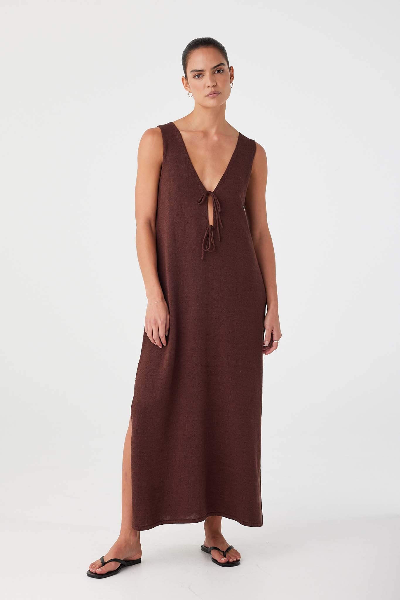 Model styled with tie side facing back. Sleeveless silhouette with soft drape and deep neckline at the rear.