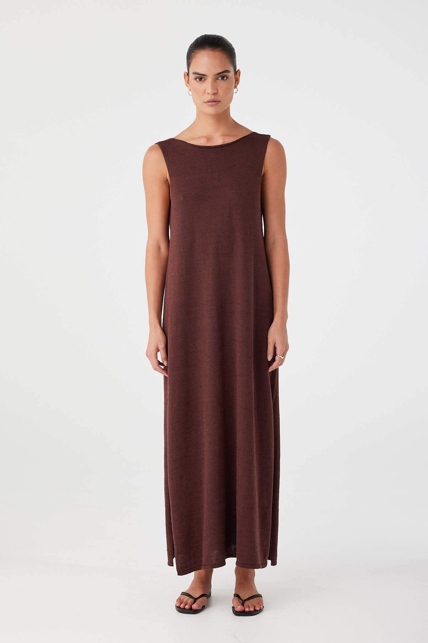 Reversible chocolate maxi dress shown with high neckline at front. Long, flowy silhouette with subtle side slits.