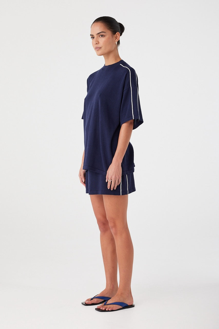 Mini skirt in navy linen cotton styled with oversized tee. Straight cut and sport-inspired detailing for elevated off-duty wear.