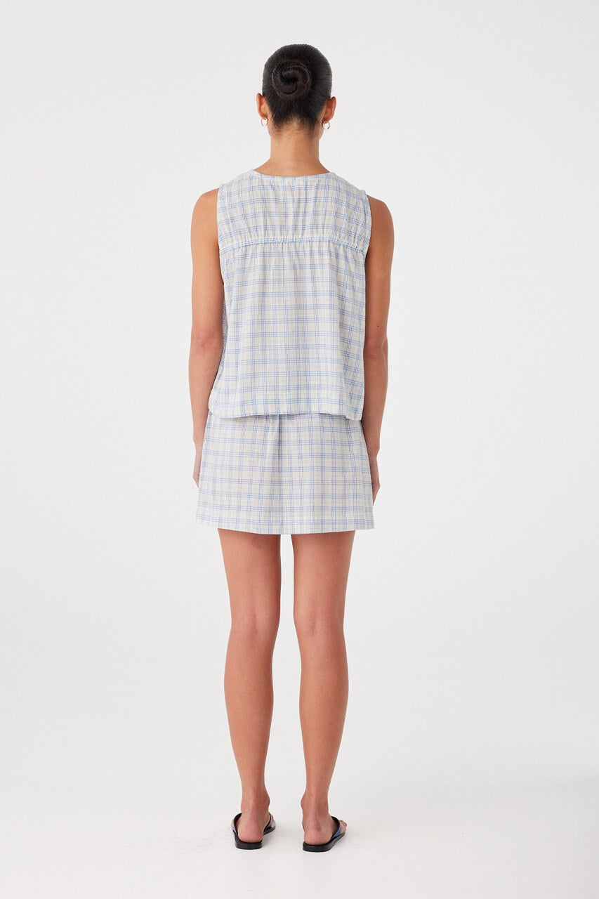 Back view of cotton check blouse with relaxed cut and soft drape. Ruched detail across the back yoke.