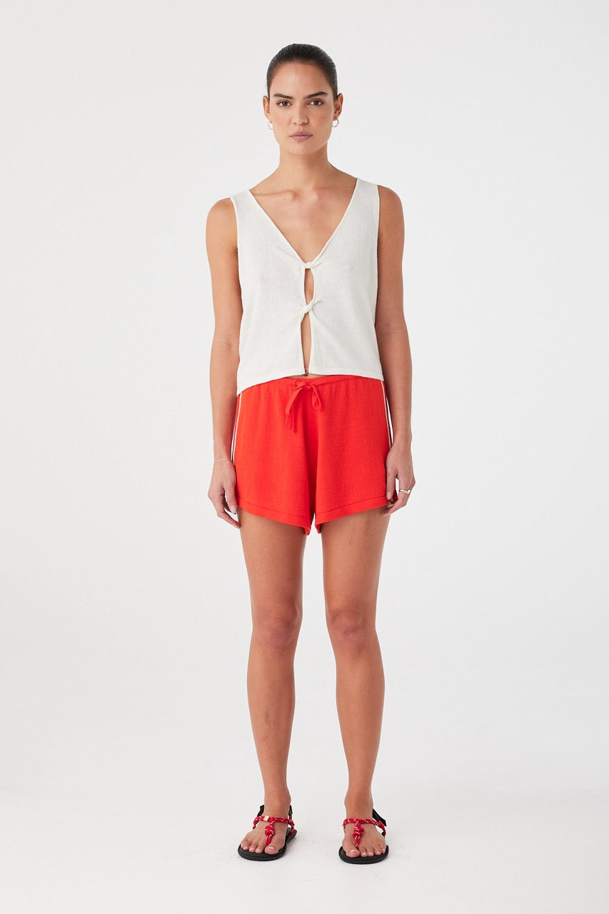 Model wears relaxed linen cotton shorts with soft drape and drawcord waist, styled for warm days.