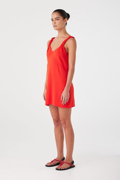 Side profile of hibiscus mini dress showing natural fibre texture and relaxed fit. Twist shoulder strap adds detail.