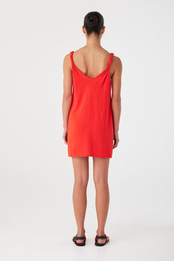 Back view of linen cotton mini dress in vibrant red. Twist straps and clean finish for effortless summer dressing.