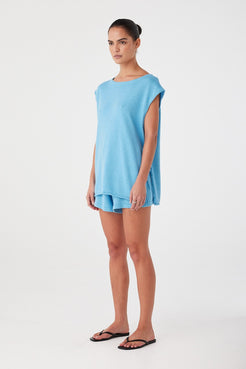 Profile of breezy tank in lightweight blend with visible texture and casual drape.