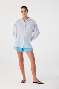 Shirt styled over light blue shorts, showcasing versatility and casual elegance.