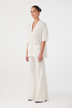 Side angle of cream crochet pants showing natural drape and soft waistband. Ideal for lightweight layering in warm weather.